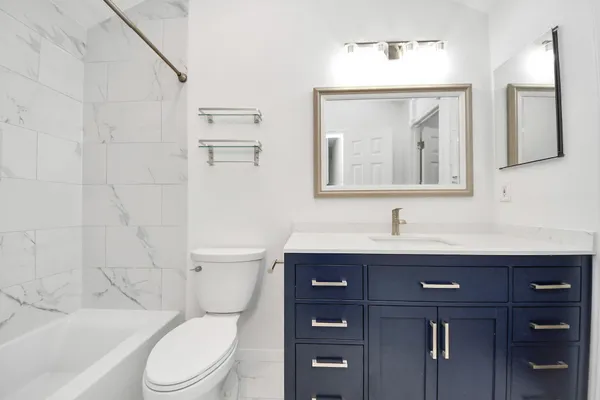 a bathroom with a bathtub shower sink and a toilet