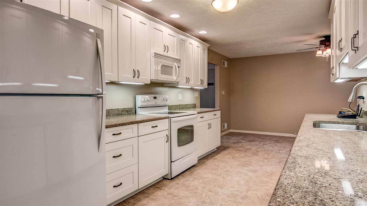 34477 Wheeler Road Kirkland, IL 60146 - Photo 9 of 25 a kitchen with granite countertop white cabinets and white appliances