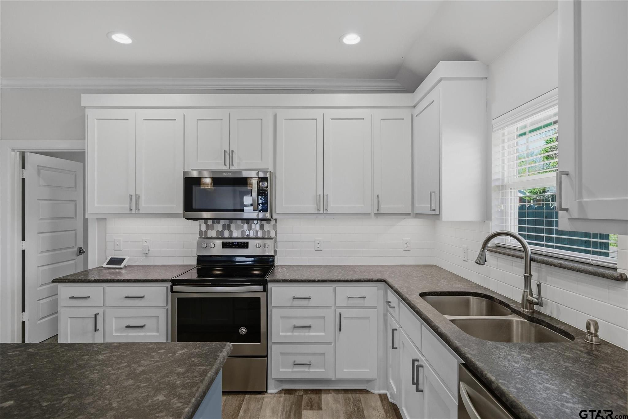 1011 Athens Street Canton, TX 75103 - Photo 11 of 38 a kitchen with granite countertop a sink stainless steel appliances and cabinets