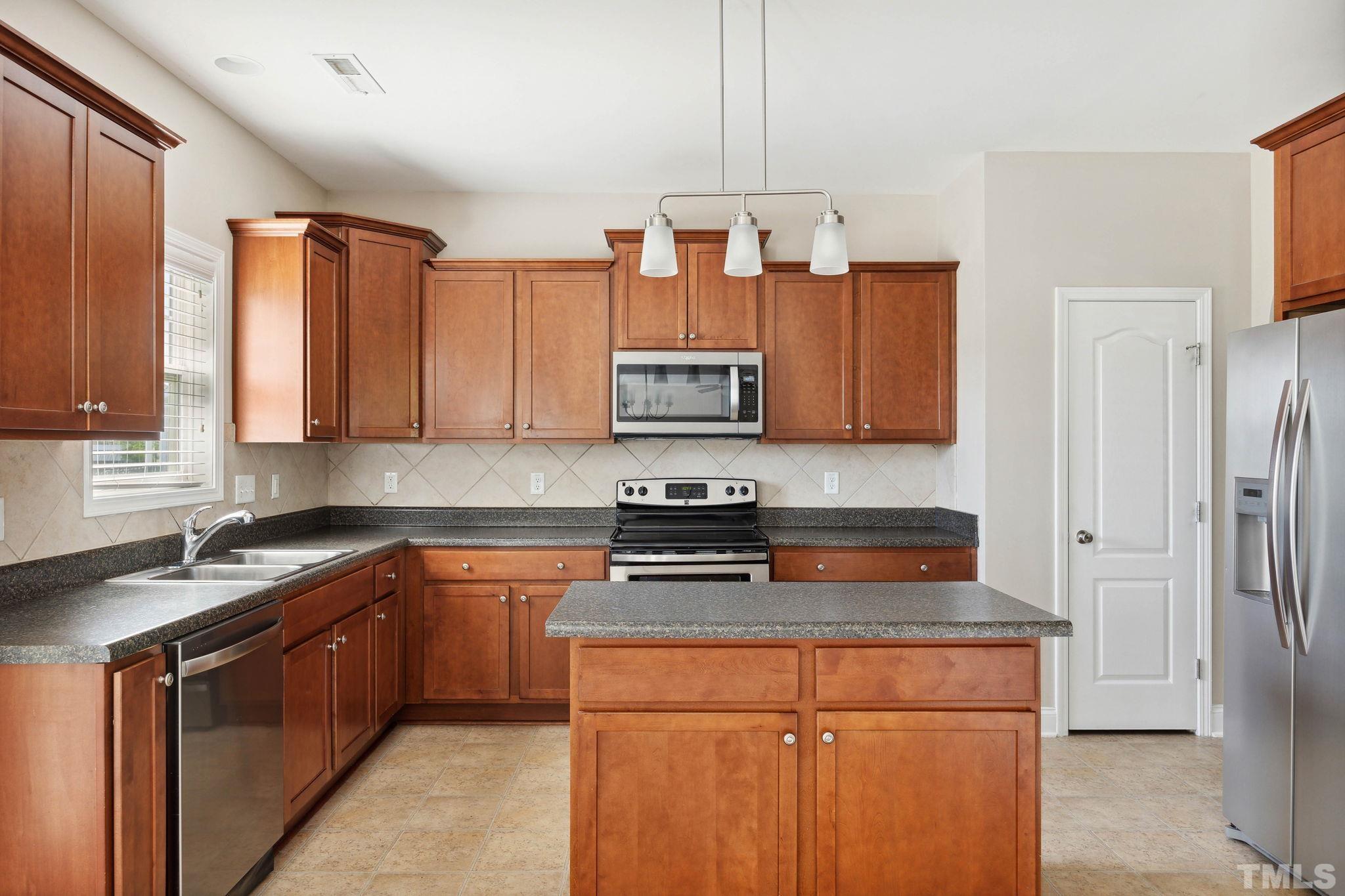 108 Riley Lane Cameron, NC 28326 - Photo 6 of 29 a kitchen with stainless steel appliances granite countertop a stove a sink dishwasher and a refrigerator