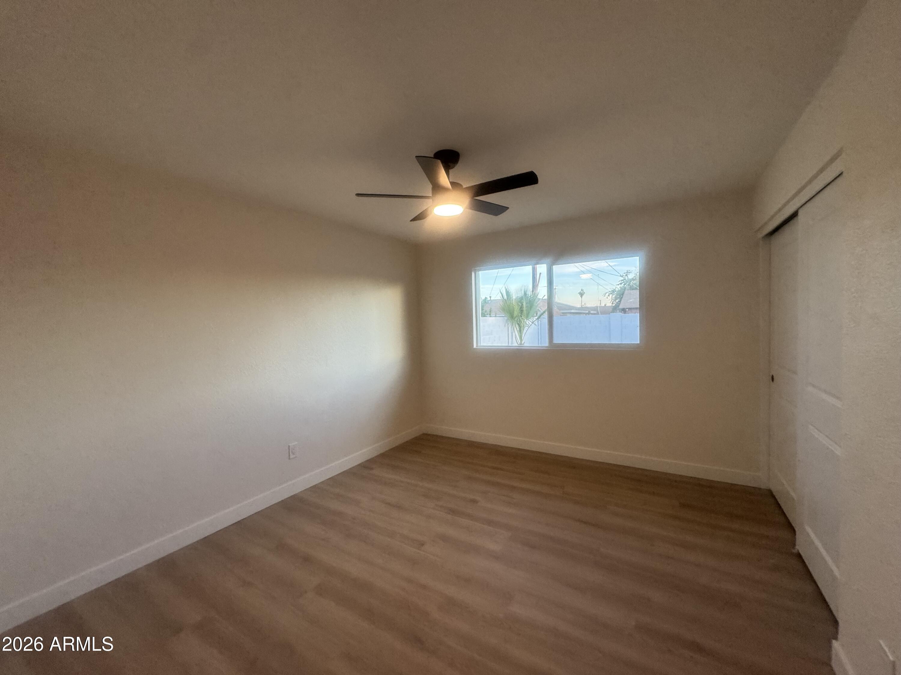 3337 West Ocotillo Road Phoenix, AZ 85017 - Photo 11 of 22 an empty room with wooden floor and windows
