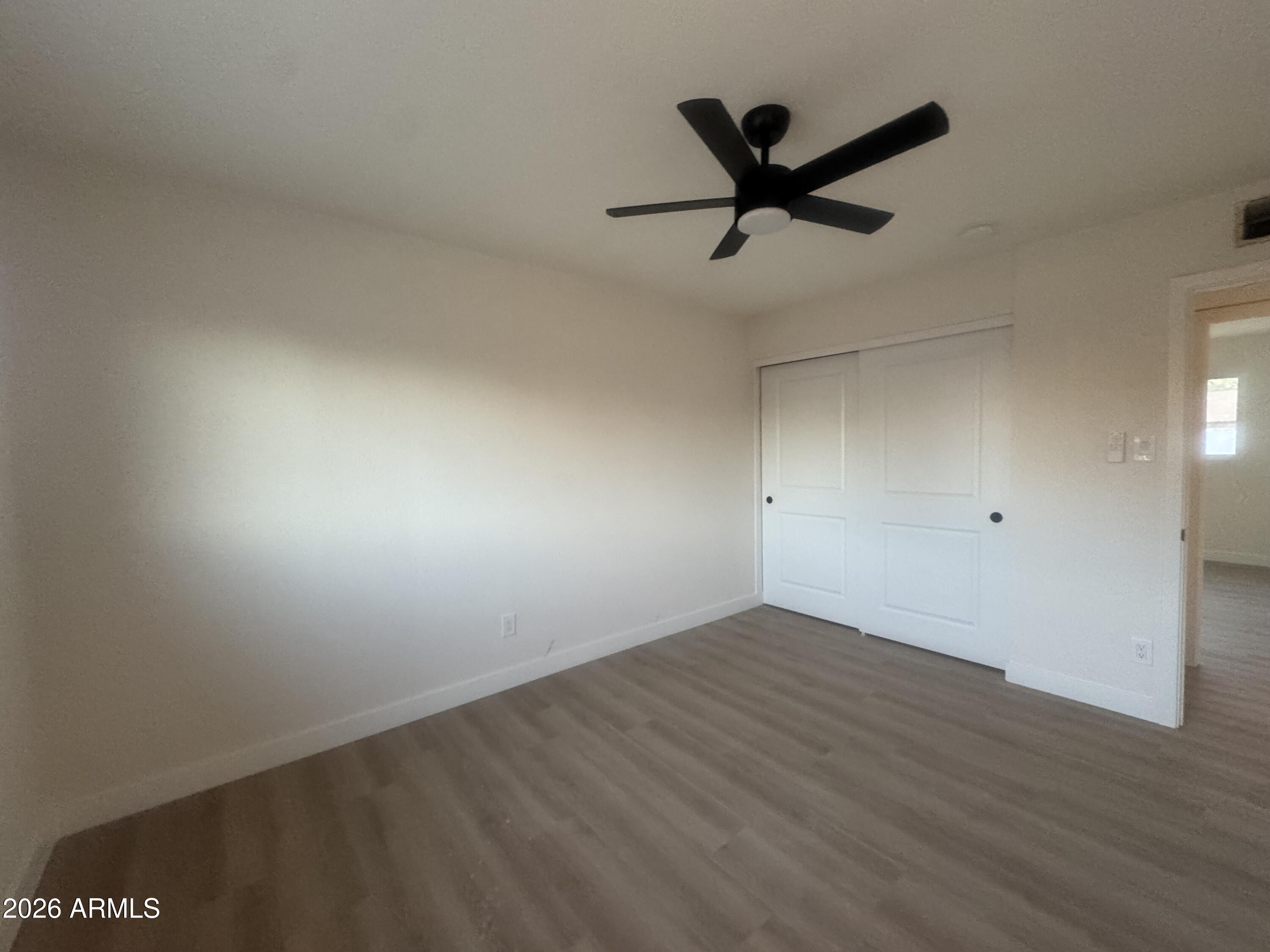 3337 West Ocotillo Road Phoenix, AZ 85017 - Photo 14 of 22 a view of empty room with wooden floor and ceiling fan
