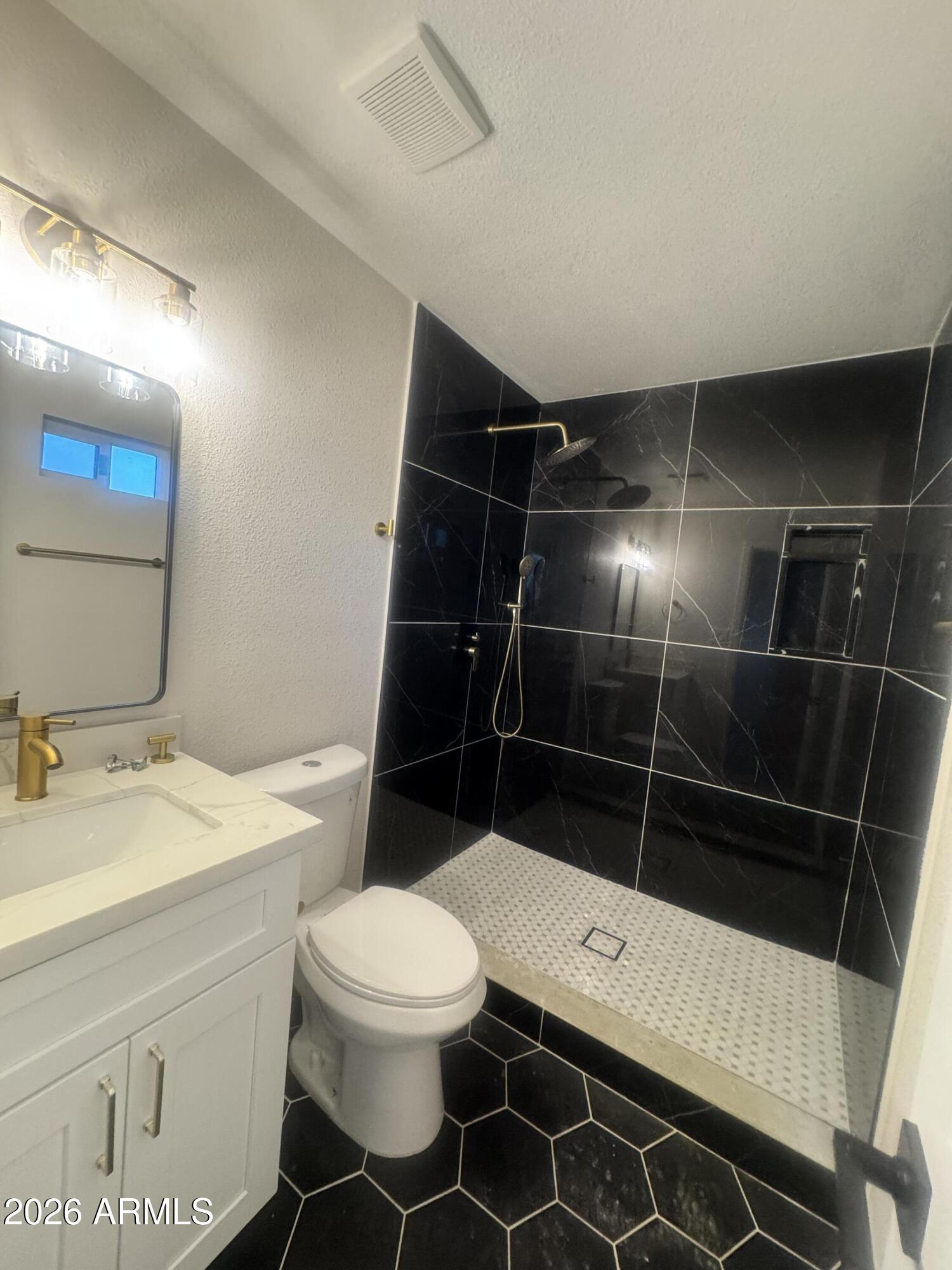 3337 West Ocotillo Road Phoenix, AZ 85017 - Photo 18 of 22 a white toilet sitting next to a bathroom sink