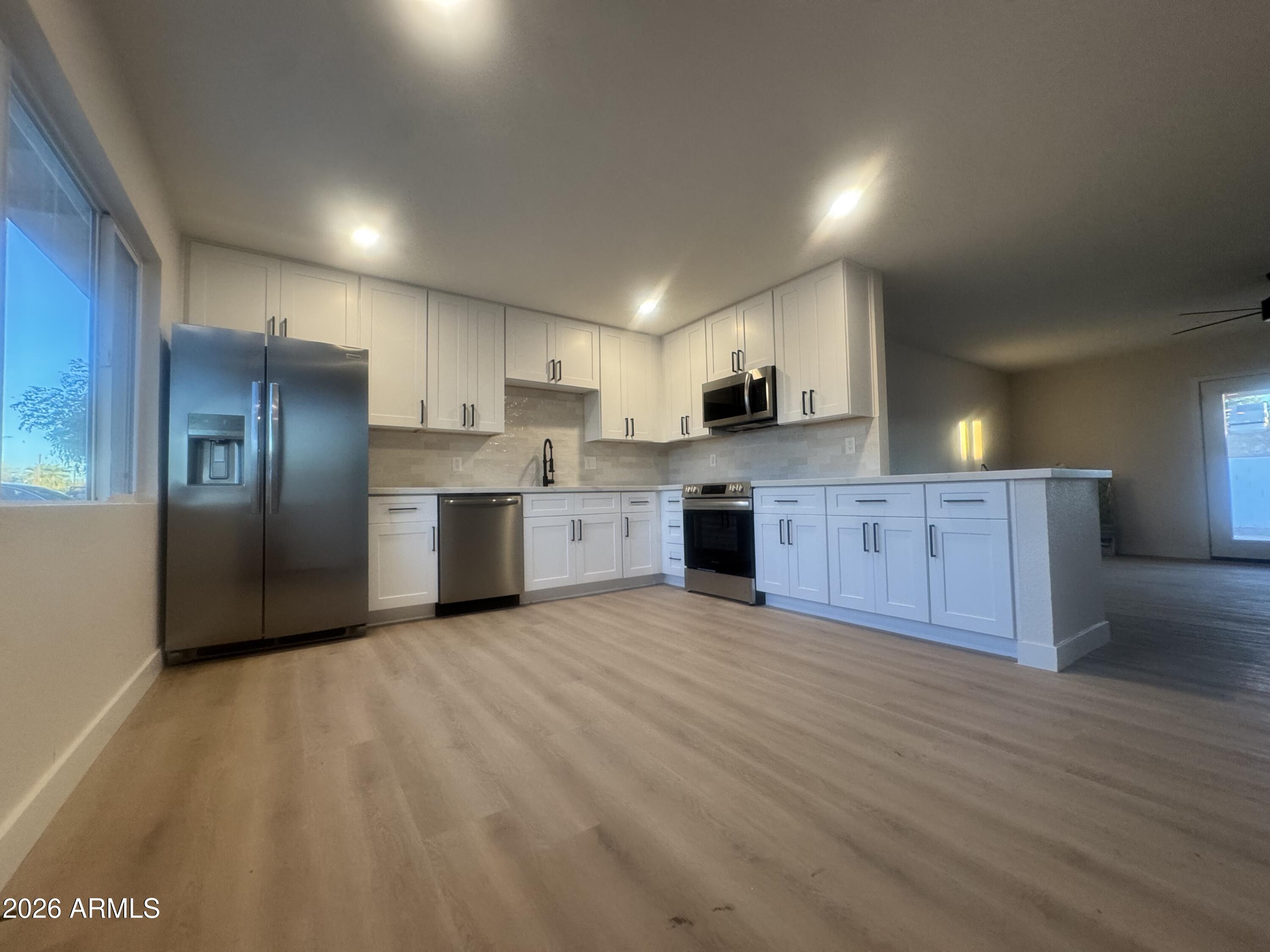 3337 West Ocotillo Road Phoenix, AZ 85017 - Photo 2 of 22 a large kitchen with stainless steel appliances granite countertop a stove a sink and a refrigerator