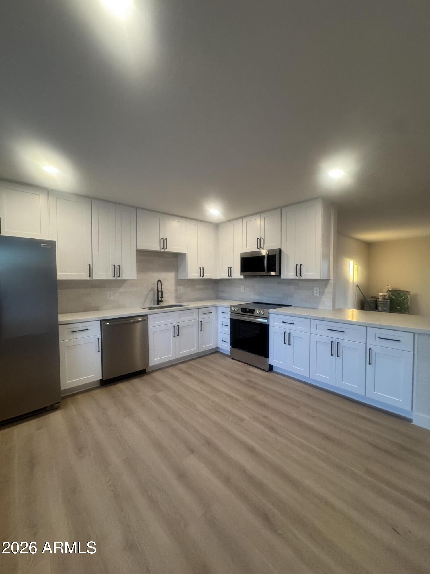 3337 West Ocotillo Road Phoenix, AZ 85017 - Photo 3 of 22 a large kitchen with stainless steel appliances granite countertop a stove a sink dishwasher and a refrigerator