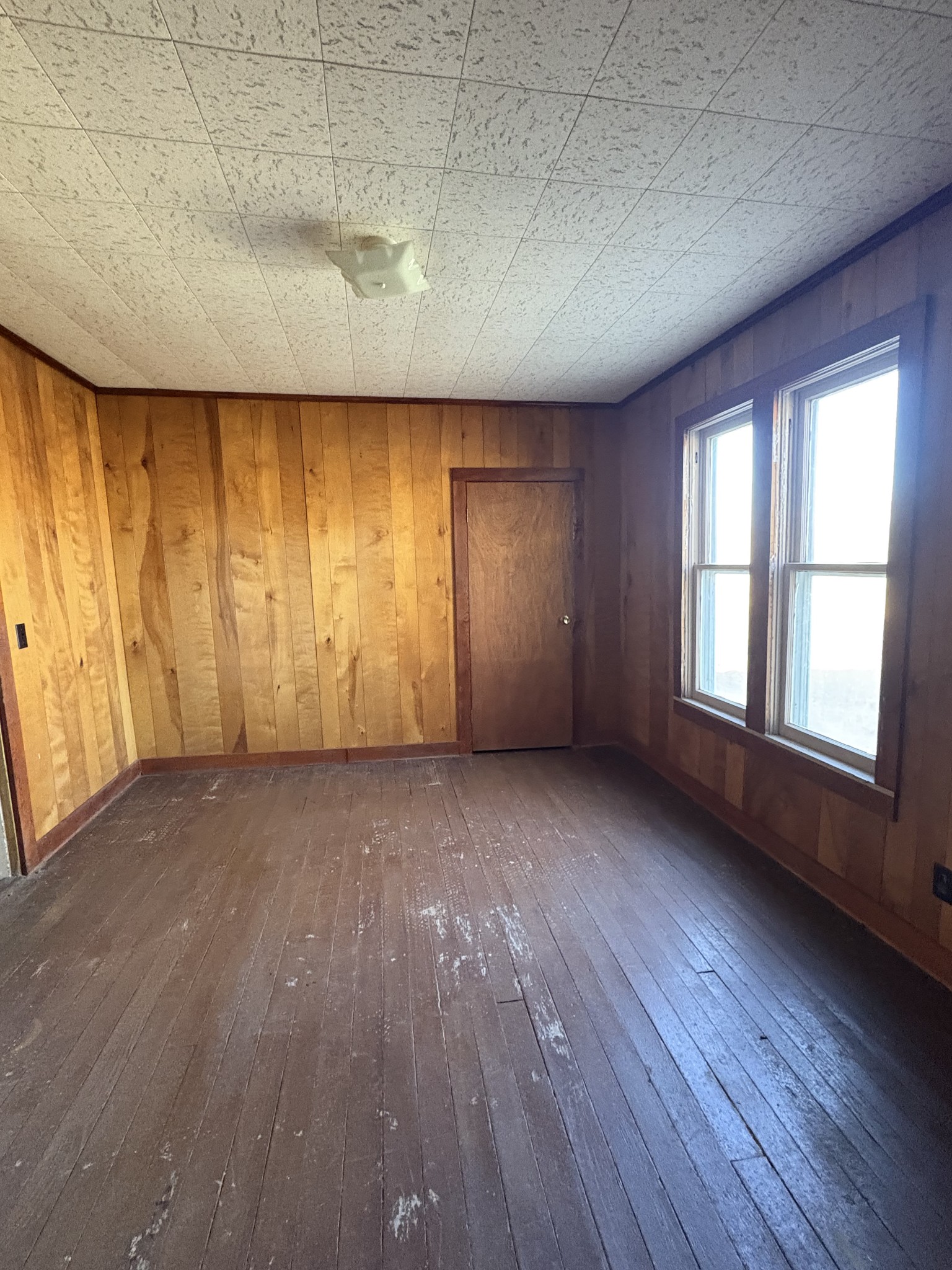 328 Lafayette Road Red Boiling Springs, TN 37150 - Photo 30 of 34 an empty room with wooden floor and windows with curtains