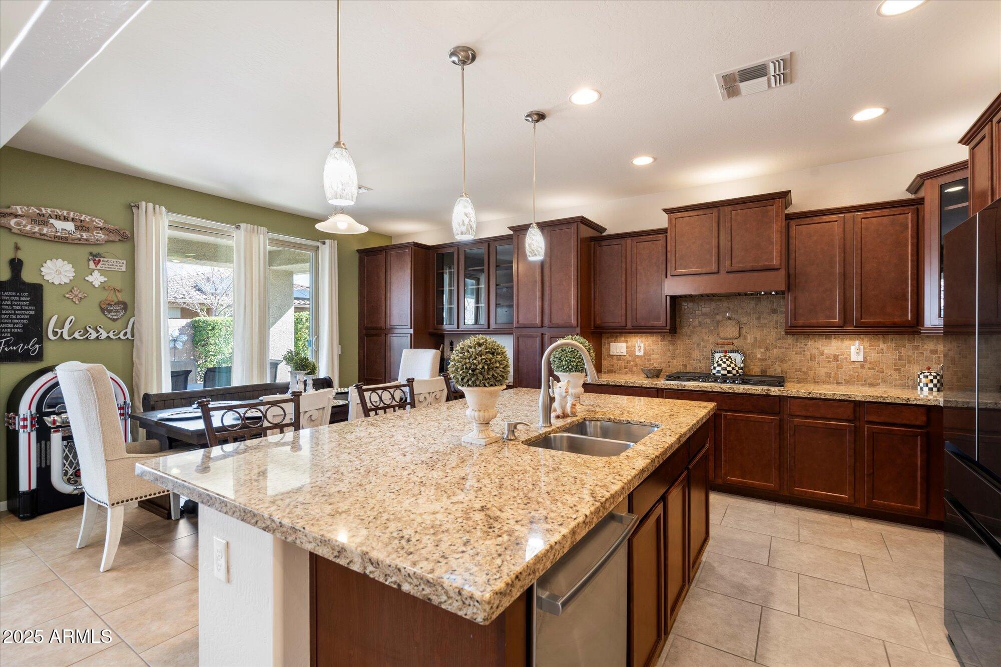 9010 West Ruth Avenue Peoria, AZ 85345 - Photo 12 of 26 a kitchen with granite countertop kitchen island stainless steel appliances a sink stove and cabinets