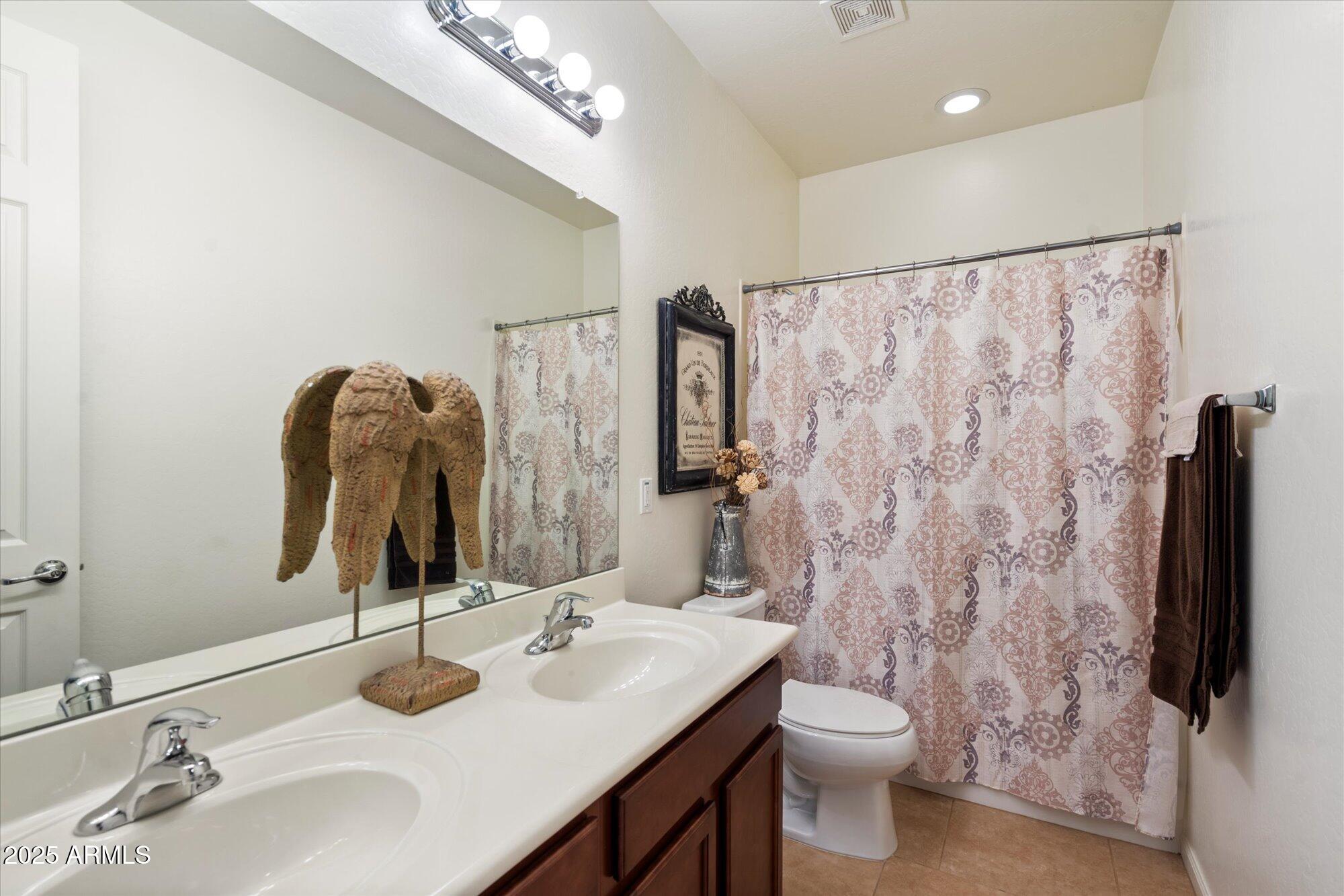 9010 West Ruth Avenue Peoria, AZ 85345 - Photo 20 of 26 a bathroom with a sink vanity mirror and toilet