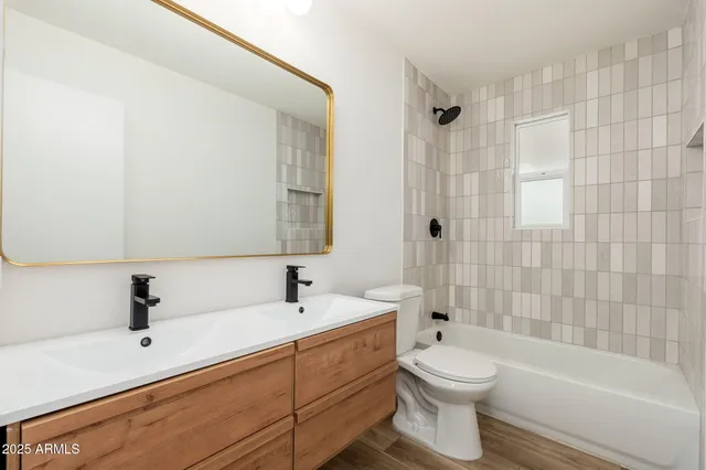 a bathroom with a toilet a sink a mirror a bathtub and shower