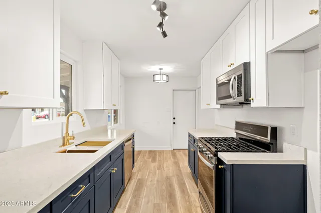 a kitchen with a sink stove top oven and cabinets