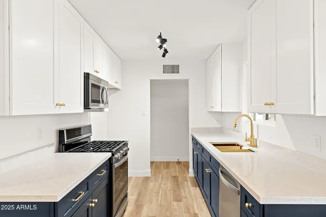 a kitchen with a sink a stove and cabinets