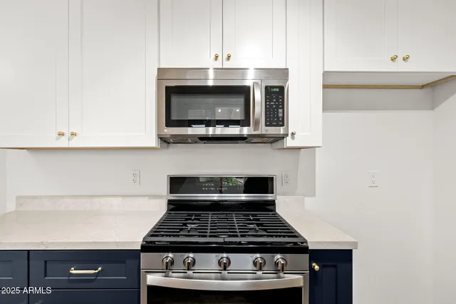 a kitchen with granite countertop a stove and a microwave