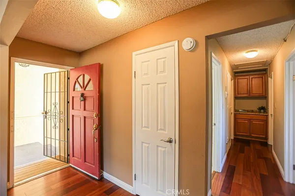 a view of a hallway with wooden floor and a bathroom