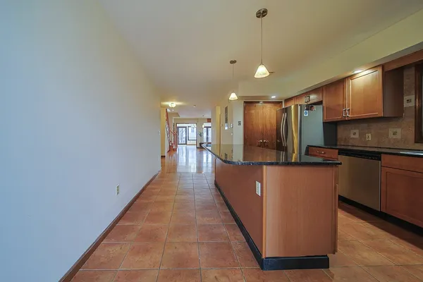a view of a kitchen with kitchen island a counter top space a sink and stainless steel appliances