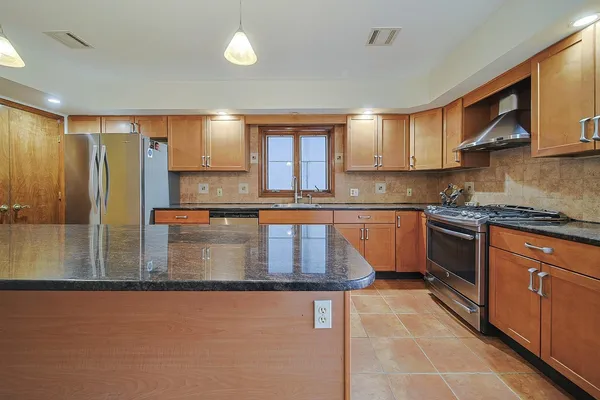 a kitchen with stainless steel appliances granite countertop a stove a sink dishwasher and a microwave