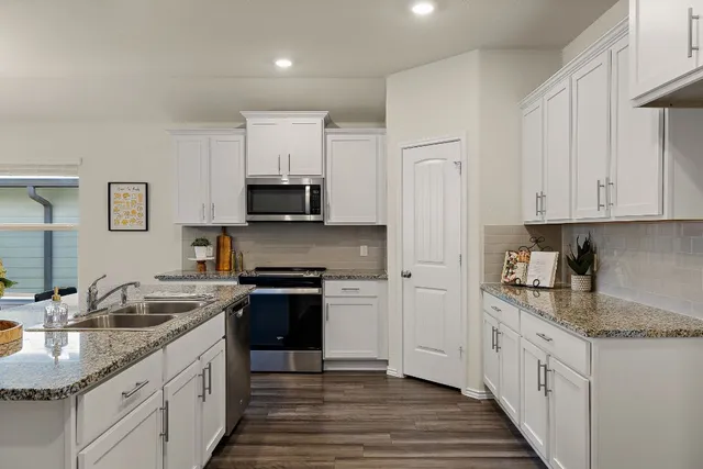 a kitchen with stainless steel appliances granite countertop a sink stove and refrigerator