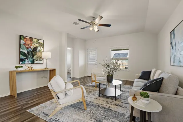 a living room with furniture and a wooden floor