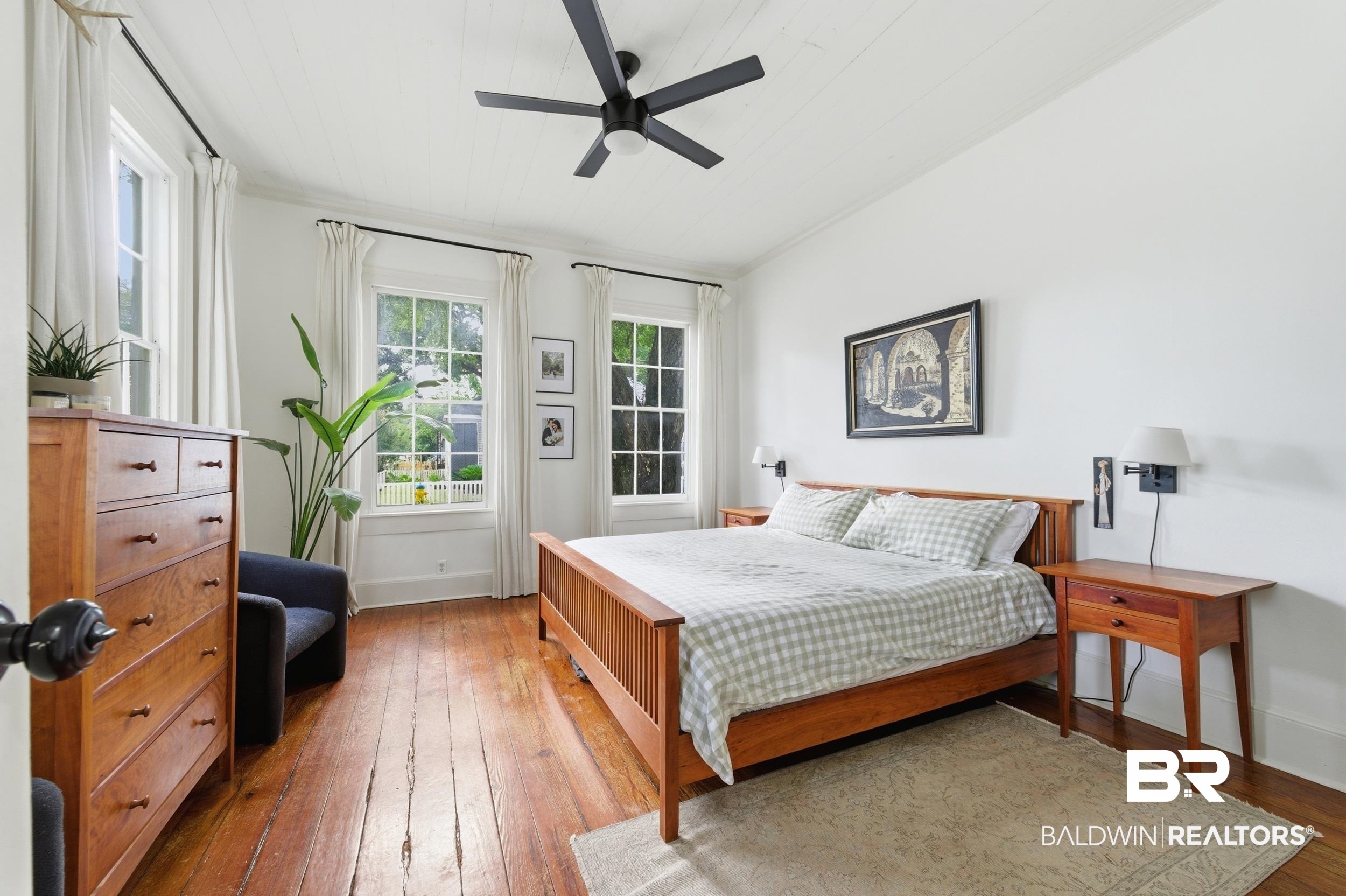 350 Charles Street Mobile, AL 36604 - Photo 18 of 52 Spacious room featuring hardwood flooring, multiple windows, a ceiling fan, and wall-mounted sconce lighting