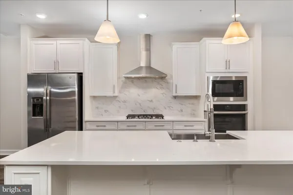 a kitchen with kitchen island a counter top space appliances and cabinets