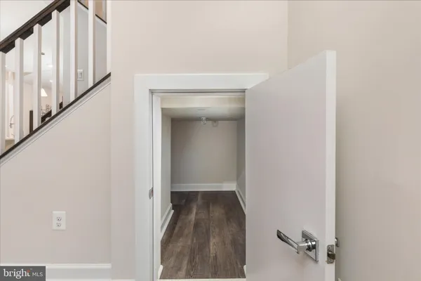 a view of a hallway with wooden floor and staircase