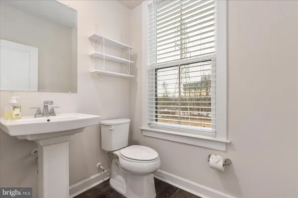 a bathroom with a sink a toilet and a window