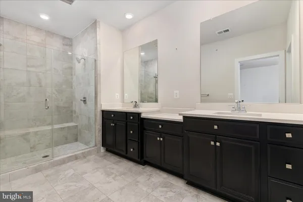 a bathroom with double vanity sink and a mirror