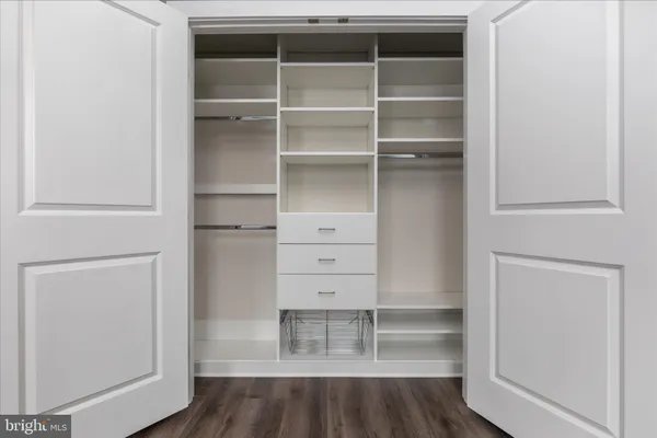 a view of walk in closet with empty racks