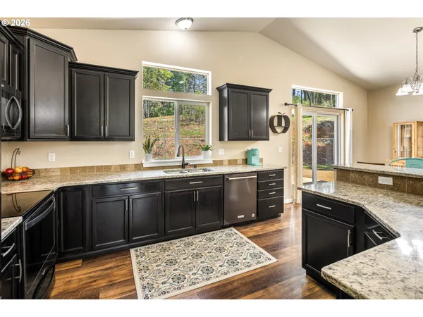 a kitchen with granite countertop a sink stainless steel appliances and cabinets