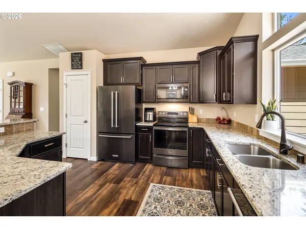 a kitchen with stainless steel appliances granite countertop a refrigerator stove and sink