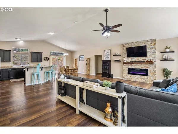 a living room with stainless steel appliances kitchen island granite countertop a stove top oven a sink a dining table and chairs