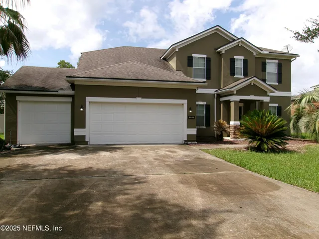 a front view of a house with a yard and garage
