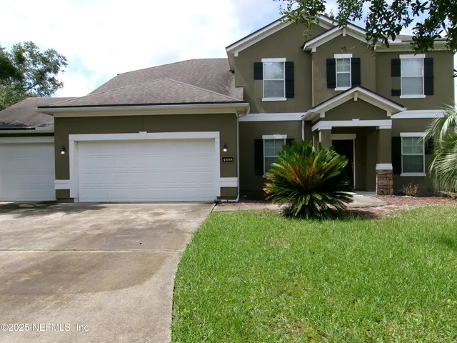 a front view of a house with a garden and plants