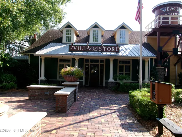 a front view of a building with entryway and palm trees
