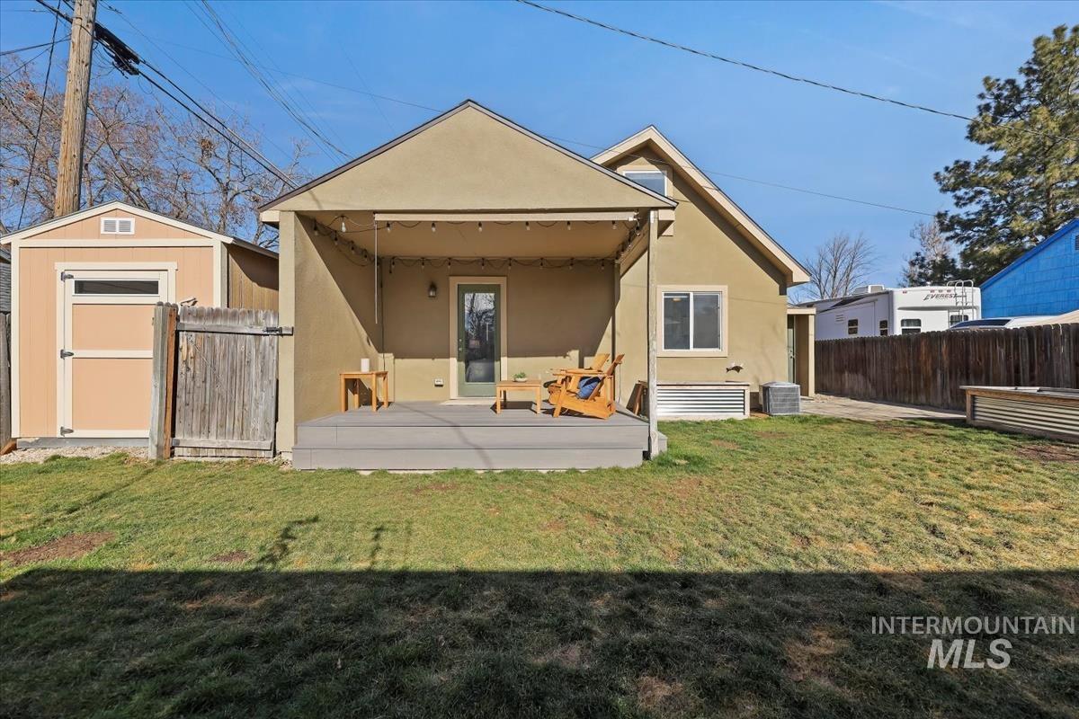 3111 West Palouse Street Boise, ID 83705 - Photo 31 of 32 Rear view of property with stucco siding, a fenced backyard, a storage shed, and a patio area
