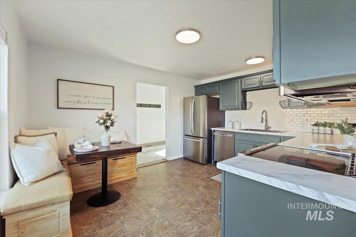 3111 West Palouse Street Boise, ID 83705 - Photo 4 of 32 Kitchen featuring light countertops, stainless steel appliances, decorative backsplash, and gray cabinetry