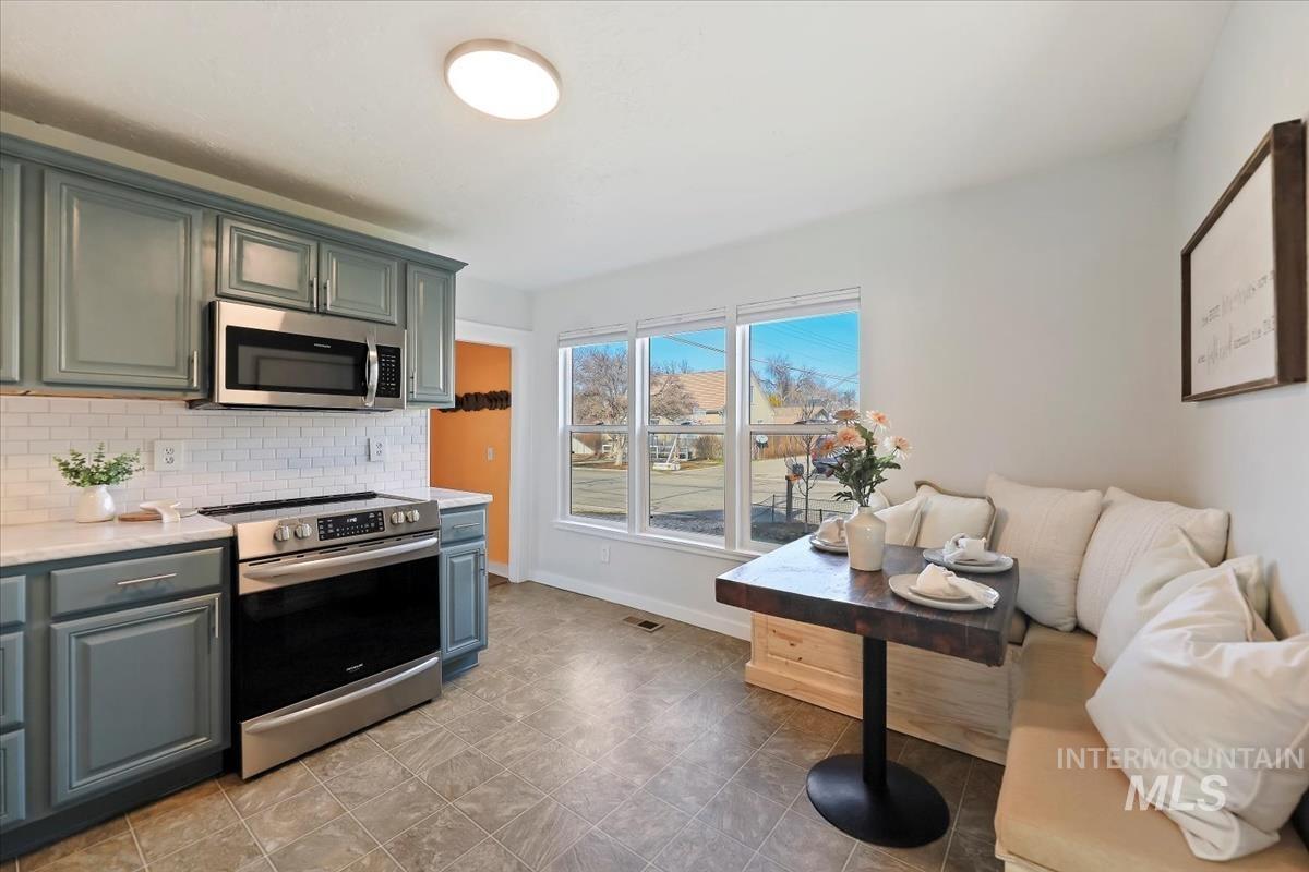 3111 West Palouse Street Boise, ID 83705 - Photo 8 of 32 Kitchen featuring stainless steel appliances, light stone counters, and tasteful backsplash