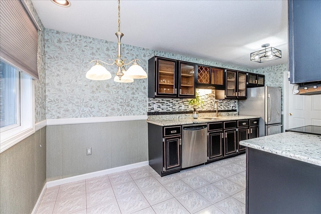 9 Ledgewood Way, Unit 9 Peabody, MA 01960 - Photo 15 of 42 a kitchen with stainless steel appliances granite countertop a stove and a sink