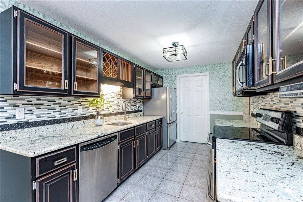 9 Ledgewood Way, Unit 9 Peabody, MA 01960 - Photo 16 of 42 a kitchen that has a sink and a stove