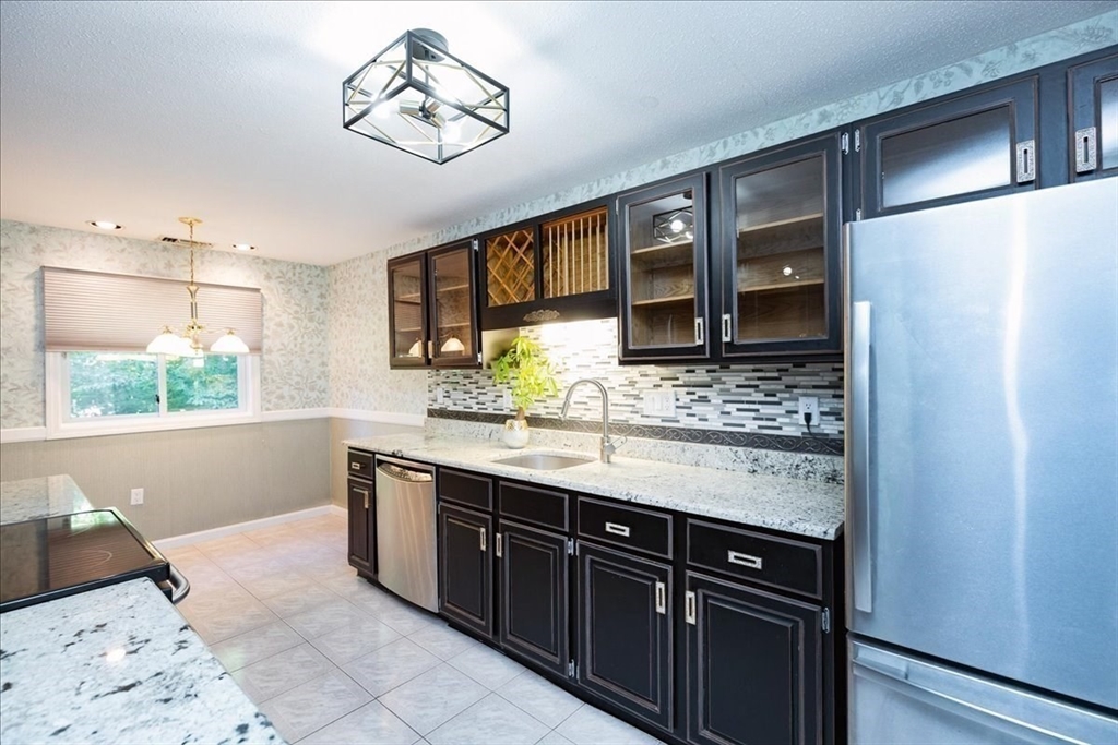 9 Ledgewood Way, Unit 9 Peabody, MA 01960 - Photo 19 of 42 a kitchen with stainless steel appliances granite countertop a sink and a stove