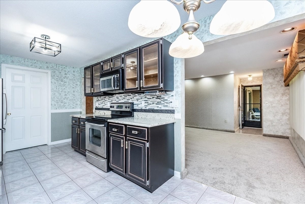 9 Ledgewood Way, Unit 9 Peabody, MA 01960 - Photo 20 of 42 a kitchen with stainless steel appliances granite countertop a stove and a sink