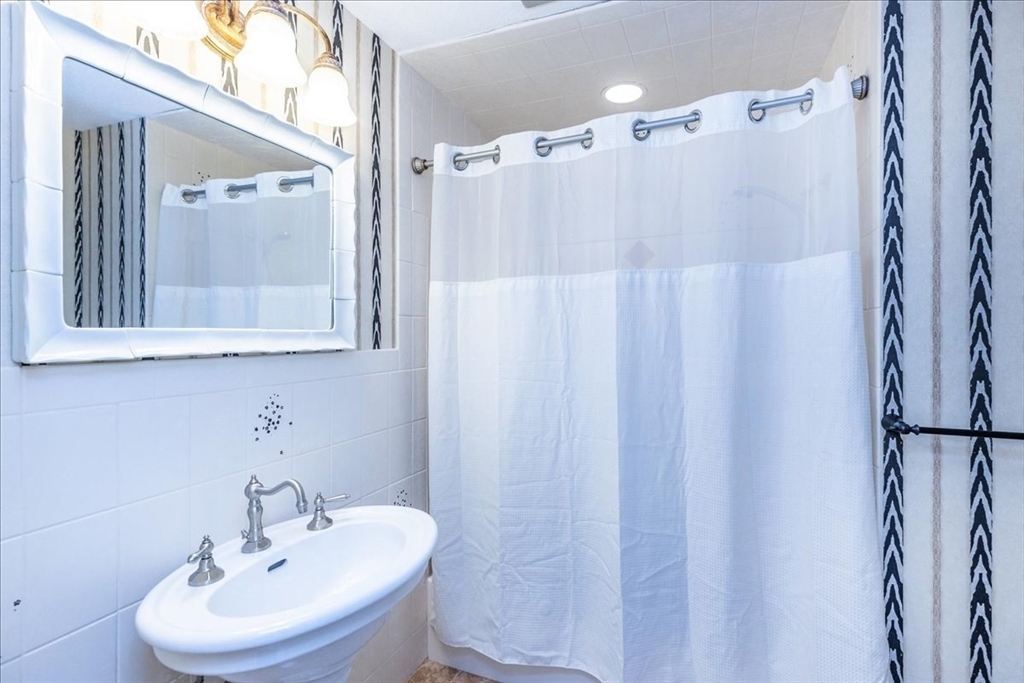 9 Ledgewood Way, Unit 9 Peabody, MA 01960 - Photo 23 of 42 a bathroom with a sink a mirror and a shower