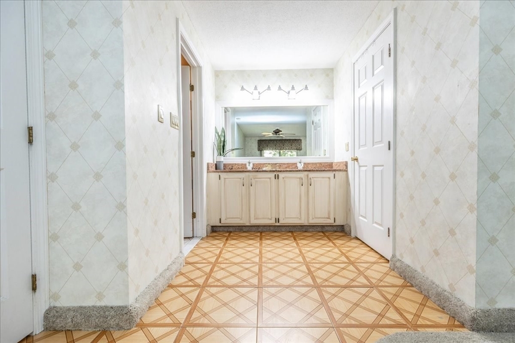 9 Ledgewood Way, Unit 9 Peabody, MA 01960 - Photo 30 of 42 a bathroom with a sink a toilet and a mirror