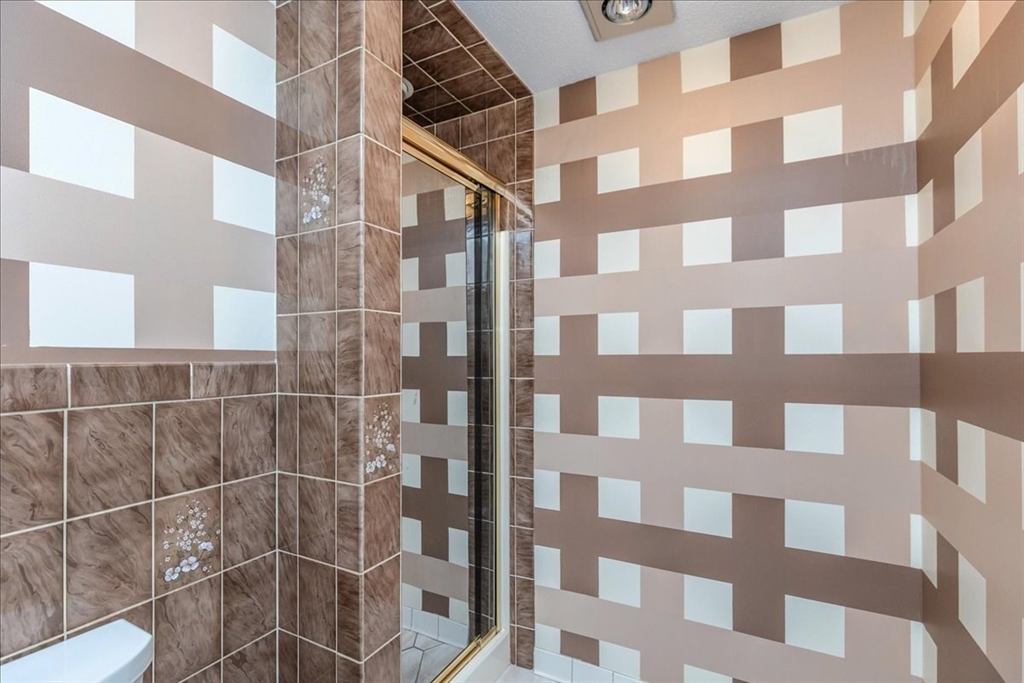 9 Ledgewood Way, Unit 9 Peabody, MA 01960 - Photo 32 of 42 a bathroom with a black and white shower curtain