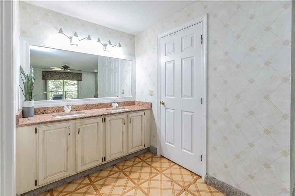 9 Ledgewood Way, Unit 9 Peabody, MA 01960 - Photo 33 of 42 a spacious bathroom with a granite countertop sink and a mirror