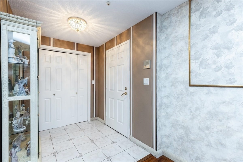 9 Ledgewood Way, Unit 9 Peabody, MA 01960 - Photo 9 of 42 a view of a hallway with wooden shelves