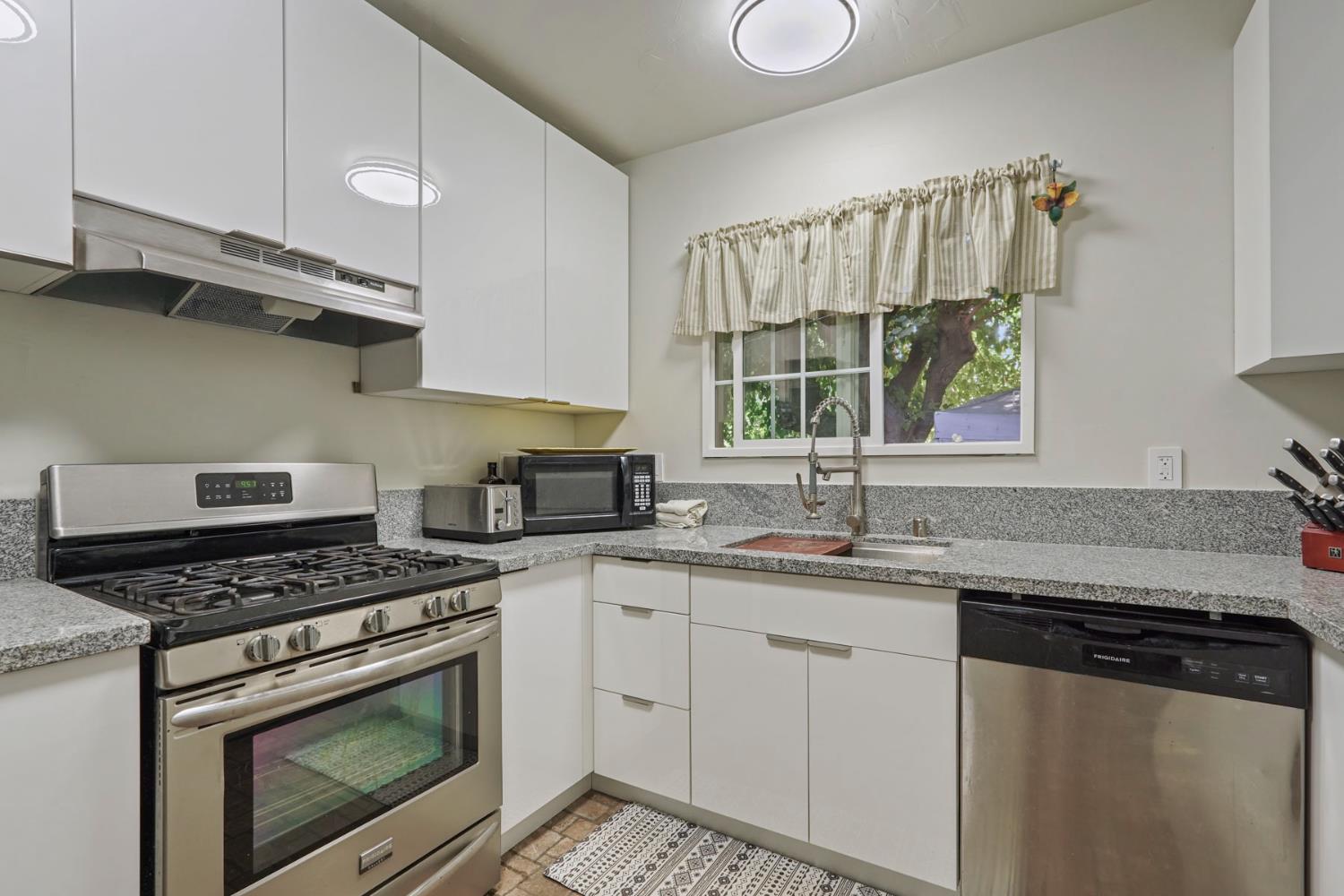 18529 Highway 88 Clements, CA 95237 - Photo 19 of 42 a kitchen with granite countertop a stove a sink and a microwave