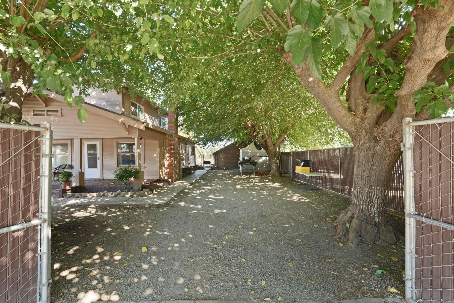 18529 Highway 88 Clements, CA 95237 - Photo 3 of 42 a tree in front of a white house