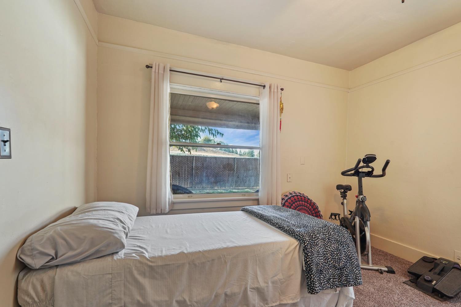 18529 Highway 88 Clements, CA 95237 - Photo 10 of 42 a bedroom with a bed and a window