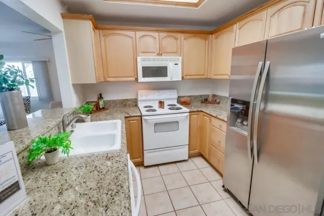 a kitchen with a sink a refrigerator and cabinets