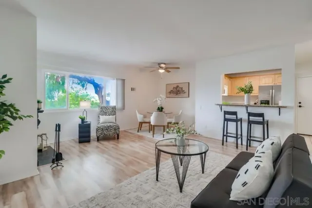 a living room with furniture a rug and a large window